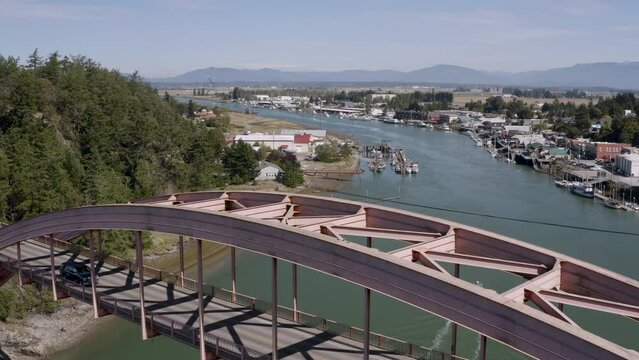 La Conner Washington Aerial View Above Swinomish Channel City Overview Sunny Day Waterfront River Mountains Fishing Boat and Traffic Crossing Bridge