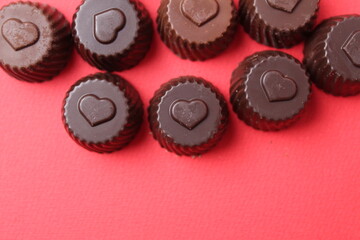chocolate case candies with the symbol of the heart. Valentine's Day of Chocolate Sweets. Candy bonbon on a red background with space for copyspace text