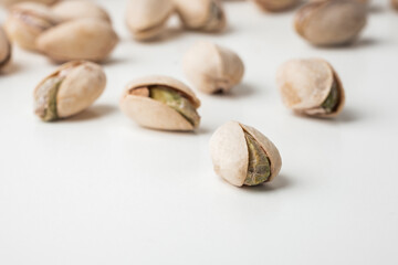 Close up of pistachio nut seeds in shells isolated on the white background. Salted dried beer snack. Macro shot
