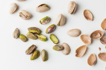 Close up of peeled pistachio nut seeds isolated on the white background. Salted dried beer snack. Macro shot