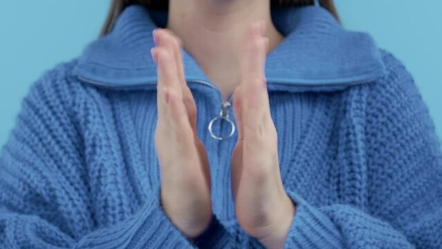 Happy woman applauding on blue background. Unrecognizable lady claps hands, congratulating. Support, cheering, gratitude concept