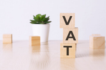 vat - financial concept. wooden cubes and flower in a pot on background