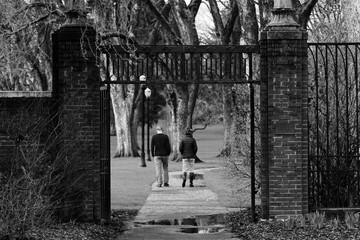 A couple strolls through an old brick gate at Oregon State University