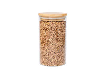 Glass jar with buckwheat on a white isolated background.