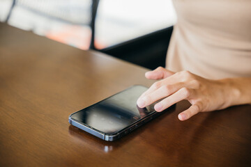 Asian young woman using smart phone for shopping online at cafe coffee shop in the morning, female has transfer money financial internet banking on mobile phone