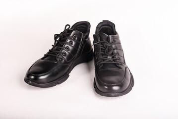 A pair of black winter boots with laces on a white background