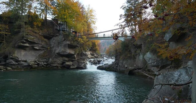 Footbridge over Prut River and Probiy waterfall, one of most beautiful and powerful waterfalls of Ukrainian Carpathians