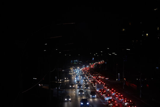 Kyiv, Ukraine - December 16, 2022: Blackout in the Ukrainian capital Kyiv. Capital streets without street lighting. Only the lights of passing cars are visible