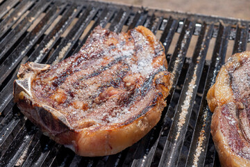 selective focus, beef steak roasted on a grill with embers