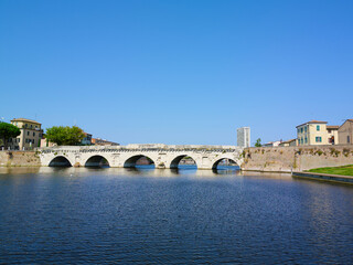 Fototapeta na wymiar Tiberius bridge in Rimini on a background of blue sky