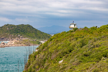 Fototapeta na wymiar Rocks, vegetation and lighthouse in Naufragados beach