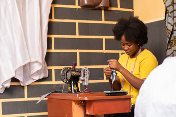 african tailor sewing with her machine