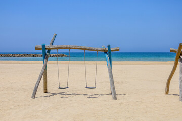 Fototapeta premium View of children's swings on sea beach