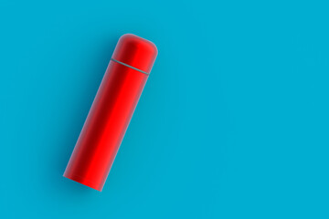 Red thermos on blue background. Metallic thermo flask. Copy space. Top view. 3d rendering
