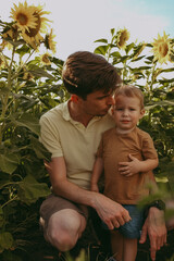 Obraz premium portrait of a father and child in a field with sunflowers in summer
