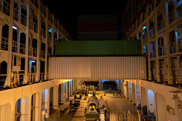 Container ship in port at container terminal. Ships of container ships stand in terminal of port on loading, unloading container at night time.