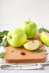 Wooden board with fresh green apples on white background, closeup