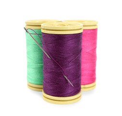 Sewing thread spools with needle isolated on white background