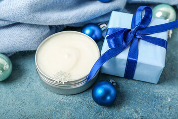 Fototapeta na wymiar Composition with jar of cream, Christmas gift, decorations and clothes on color background, closeup