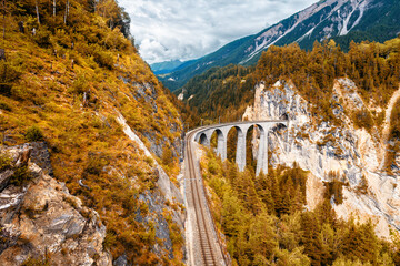 Landwasserviaduct in de herfst, Zwitserland. Toneelmening van spoorweg in bergen