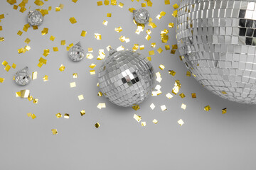 Disco balls with confetti on grey background