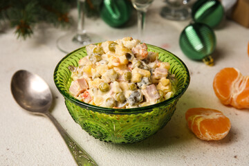 Bowl of Olivier salad on white table, closeup