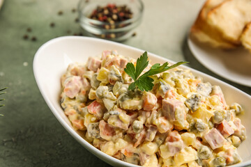 Bowl of Olivier salad on grunge background, closeup