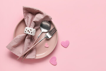 Table setting for Valentine's Day with hearts on pink background