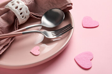 Table setting for Valentine's Day with hearts on pink background, closeup
