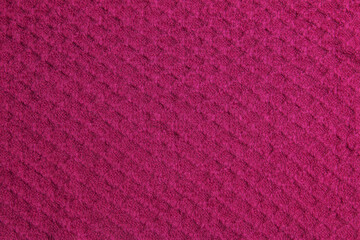 Fototapeta premium Knitted background in crimson color. Knitted texture of woolen fabric.