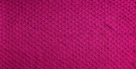 Knitted background in crimson color. Knitted texture of woolen fabric.