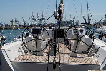 White sailing yacht on the quay in the port on a cloudy day, view from the stern. High-quality...