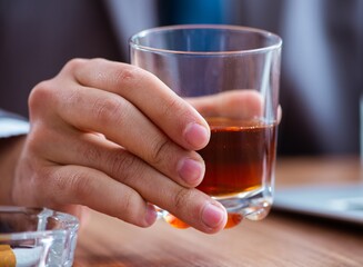 Male employee drinking alcohol and smoking cigarettes at workpla
