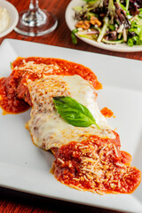 Chicken Parmesan or parmigiana. Italian comfort dish. Chicken breast covered in breadcrumbs fried, topped with marinara sauce, melted mozzarella, parmigiana and provolone cheeses and Italian parsley.