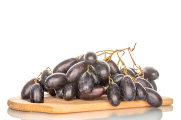 One bunch of ripe black grapes on a wooden board, close-up, isolated on white.