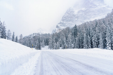 Snowy mountain pass road in the Alps during a blizzard in winter. Dangerous driving conditions.