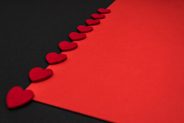 Black and red background, divided diagonally, decorated with red hearts