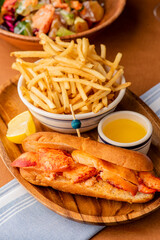 Lobster Roll. Traditional classic American Sandwich. New England classic, fresh Maine Lobster boiled, mixed with mayo, celery, chives served in toasted hero roll with crisp lettuce and drawn butter.