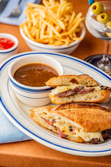 Reuben Sandwich. Classic traditional American sandwich. Pastrami and corned beef on grilled rye bread, melted Swiss cheese, sauerkraut, topped with thousand island dressing served french fries.