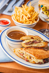 Reuben Sandwich. Classic traditional American sandwich. Pastrami and corned beef on grilled rye bread, melted Swiss cheese, sauerkraut, topped with thousand island dressing served french fries.