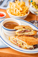 Reuben Sandwich. Classic traditional American sandwich. Pastrami and corned beef on grilled rye bread, melted Swiss cheese, sauerkraut, topped with thousand island dressing served french fries.