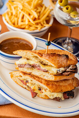 Reuben Sandwich. Classic traditional American sandwich. Pastrami and corned beef on grilled rye bread, melted Swiss cheese, sauerkraut, topped with thousand island dressing served french fries.