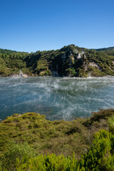 Steam rising from a lake at waimangu volcanic valley in Rotorua New Zealand