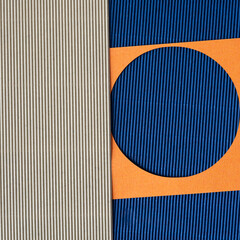 orange paper circle-frame on blue and beige corrugated paper background