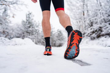 unknown man running in snow in winter day close up on shoe sneakers