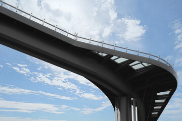 Beautiful pedestrian bridge with viewing platform against cloudy sky, low angle view