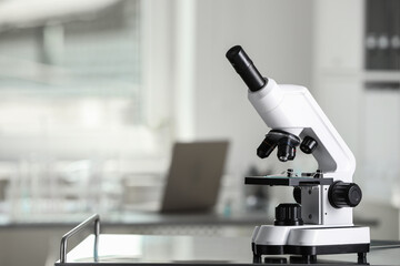 Modern medical microscope on metal table in laboratory, space for text