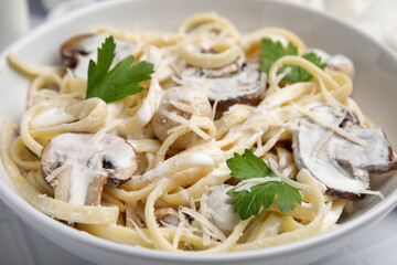 Delicious pasta with mushrooms in bowl, closeup