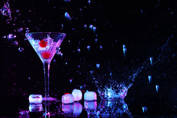 Martini splashing out of glass near ice on black background