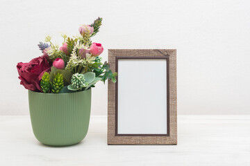 Blank picture frame mockup on white cupboard. White living room design. Home staging and minimalism concept